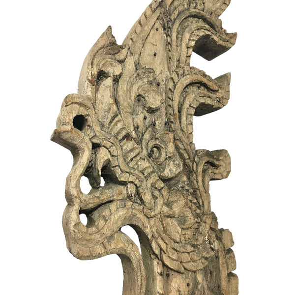 Head of an antique 1800s Thai wooden temple dragon architectural element with intricate carvings and a natural patina.