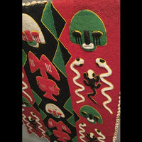 1950s Yoruba ceremonial beaded tunic with animal motifs and abstract patterns, displayed on a metal stand.